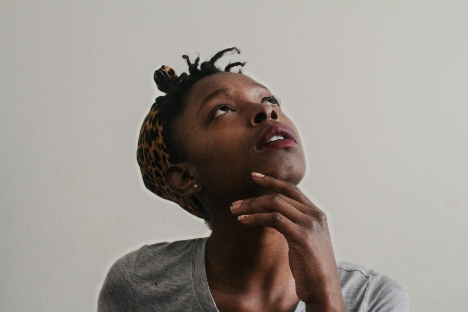 A person pausing, hand on chin, thinking about who should take the next request
